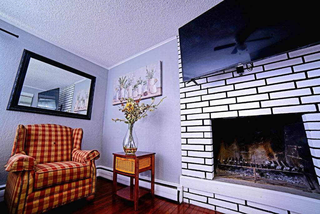 a living room with a fireplace and a chair at SHALIGOHOMES QUEEN SUITE ON 16TH in Anchorage