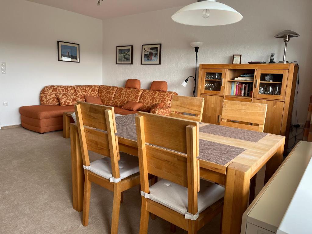 ein Wohnzimmer mit einem Tisch und einem Sofa in der Unterkunft Tief 12 Strandkieker mit Internet und Strandkorb 54 in Wangerland
