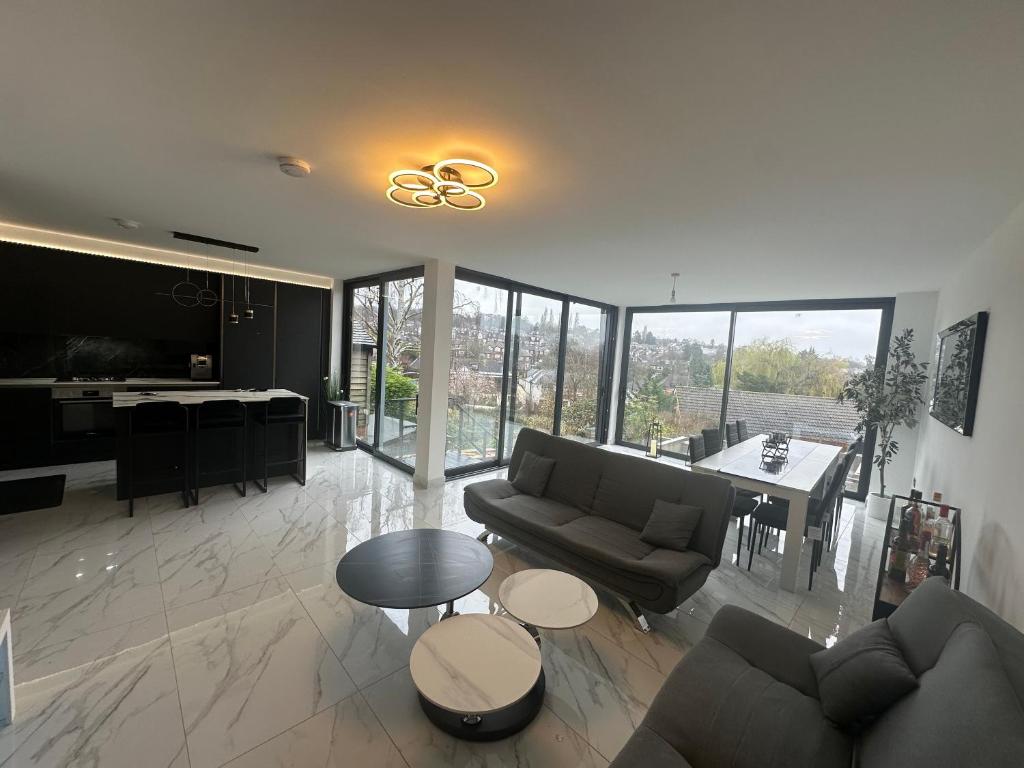 巴內特的住宿－Luxurious & Elegant 6-Bed House，带沙发和桌子的客厅以及厨房。