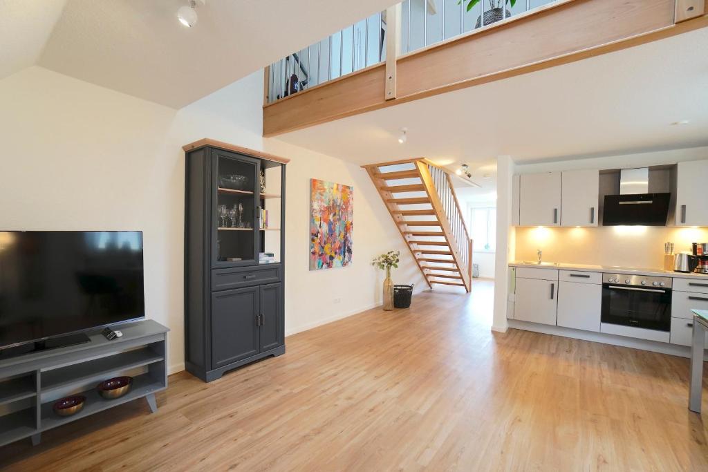 ein Wohnzimmer mit einem TV und einer Treppe in der Unterkunft Apartement Dom-Blick in Schleswig