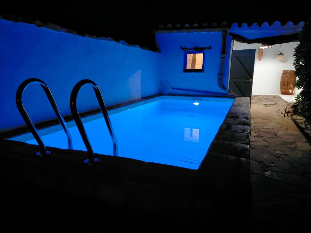 - une piscine avec éclairage bleu dans une pièce bleue dans l'établissement Casa Rural tía Salomé, à Sant Jordi