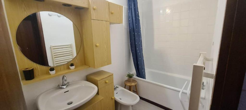 y baño con lavabo, espejo y bañera. en Appartement 4/6 places pied des pistes, en Saint-Lary-Soulan