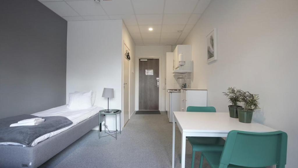 - une chambre avec un lit, une table et des chaises dans l'établissement Forenom Hostel Gothenburg Säve, à Göteborg