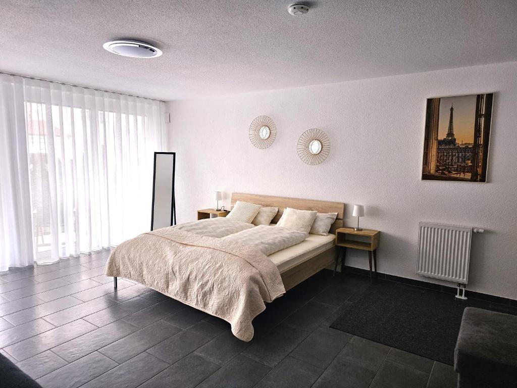 een slaapkamer met een groot bed en 2 klokken aan de muur bij MY HOME N 35/2 in Villingen-Schwenningen