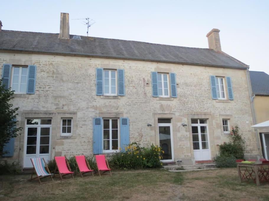 - un groupe de chaises devant une maison en pierre dans l'établissement Grande et belle maison normande, à Martragny