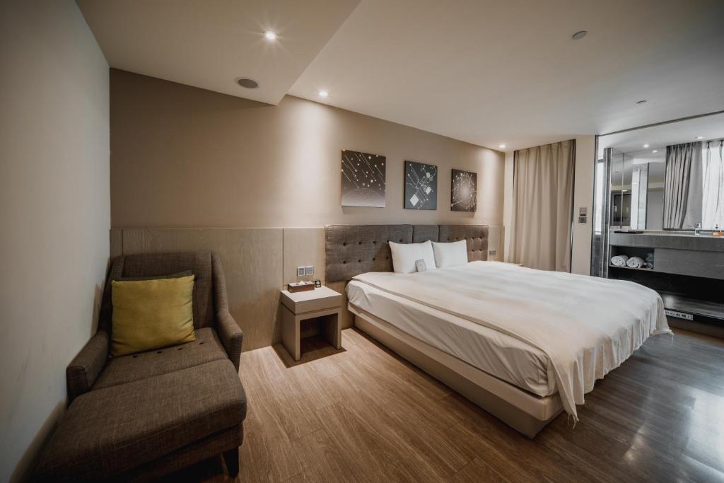 a hotel room with a bed and a couch at Hub Hotel Kaohsiung Yawan Branch in Kaohsiung