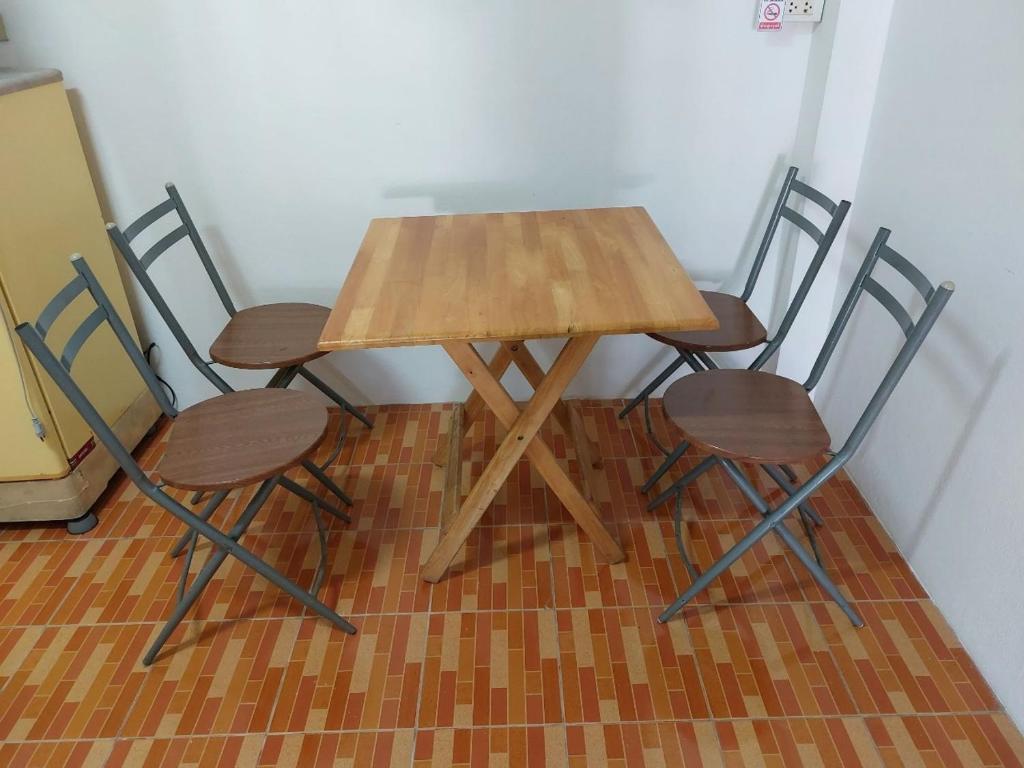 a wooden table and four chairs in a room at Classic Home Stay Hatyai in Ban Tha Sae