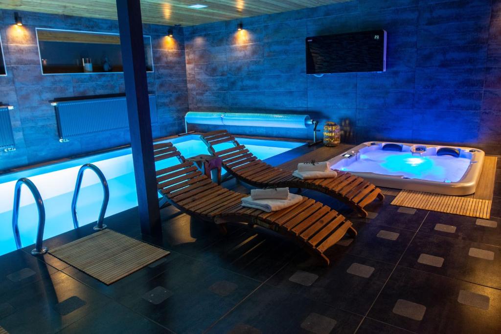um quarto com uma piscina com cadeiras e uma banheira em Pod Vojtěchem - soukromý wellness apartmán em Wotitz