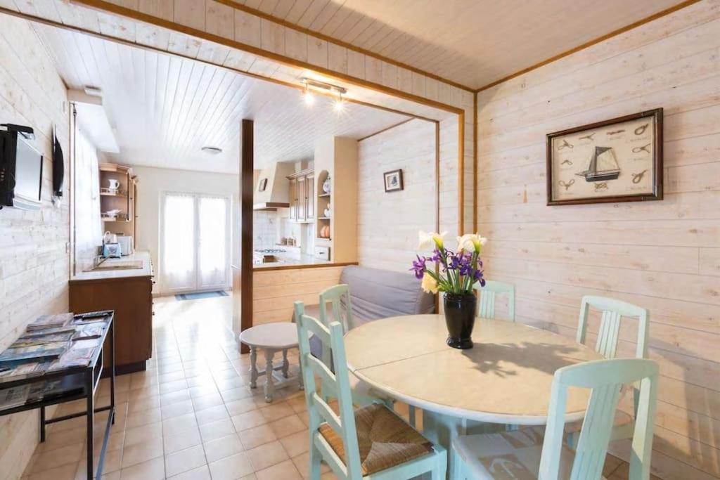 una cucina e una sala da pranzo con tavolo e sedie di Maison avec jardin proche gare plage intramuros chien admis Fibre a Saint Malo