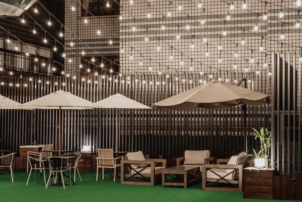 a restaurant with tables and chairs and lights at Hub Hotel Kaohsiung Yawan Branch in Kaohsiung