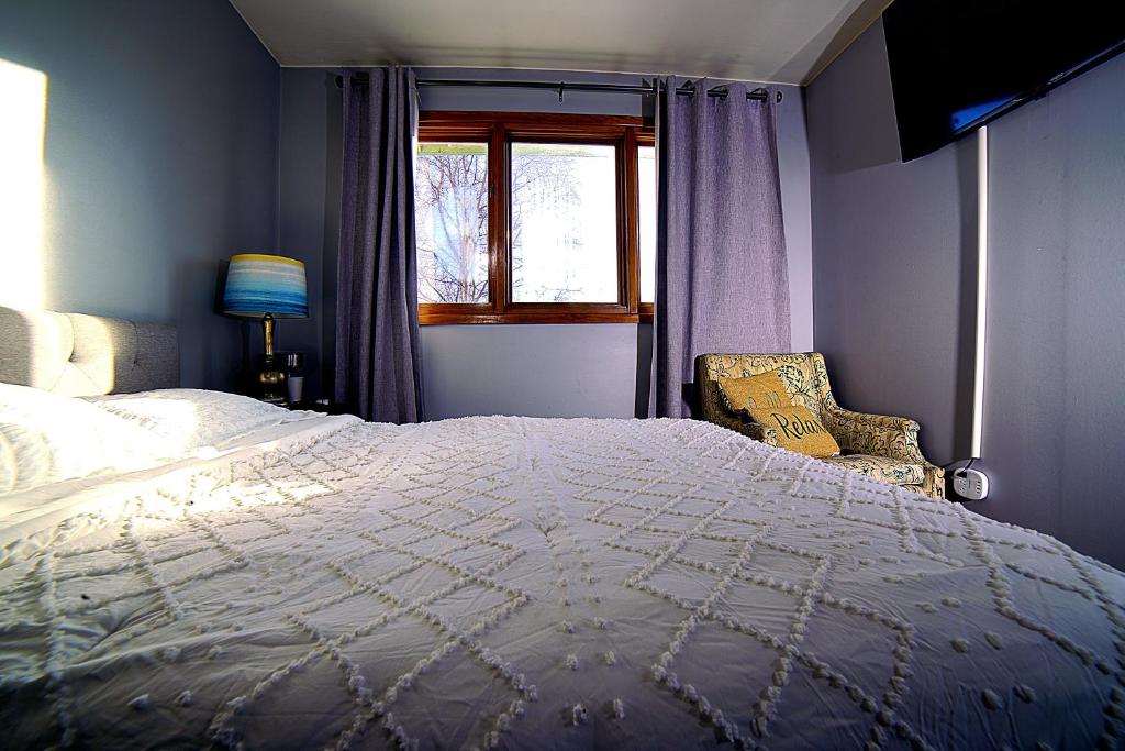 a bedroom with a large bed and a window at Quiet And Comfortable Deluxe in Anchorage