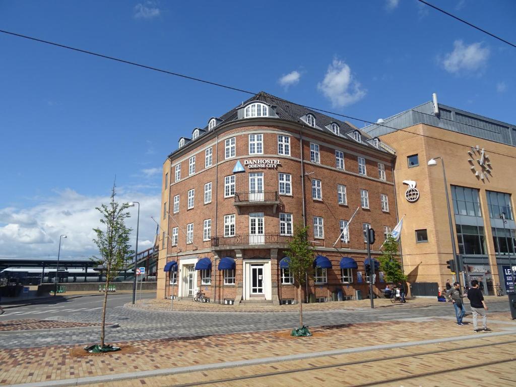 um grande edifício de tijolos na esquina de uma rua em Danhostel Odense City em Odense