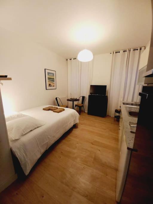 um quarto com uma cama branca e uma mesa em Le 29 cuty, wifi, à 3min de la gare sncf em Agen