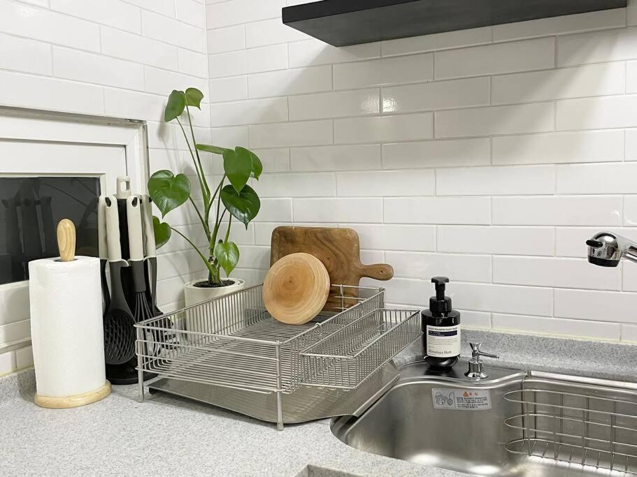 a kitchen sink with a dish drying rack next to it at Modeul Stay in Seoul