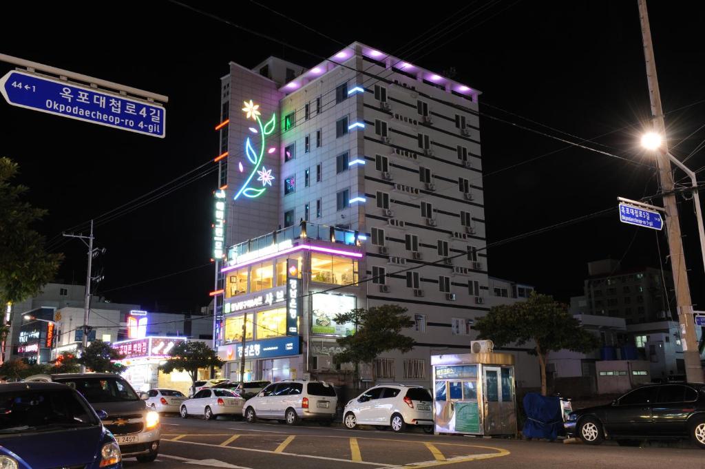 a building with neon lights in a city at night at Evergreen motel in Geoje 