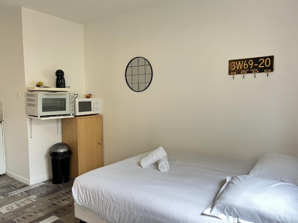 - une petite chambre avec un lit et un four micro-ondes dans l'établissement Le Vinci 3, à Calais