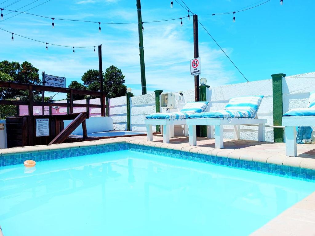 - une piscine avec 2 chaises et une table dans l'établissement Queensburgh B&B or Self Catering, à Durban