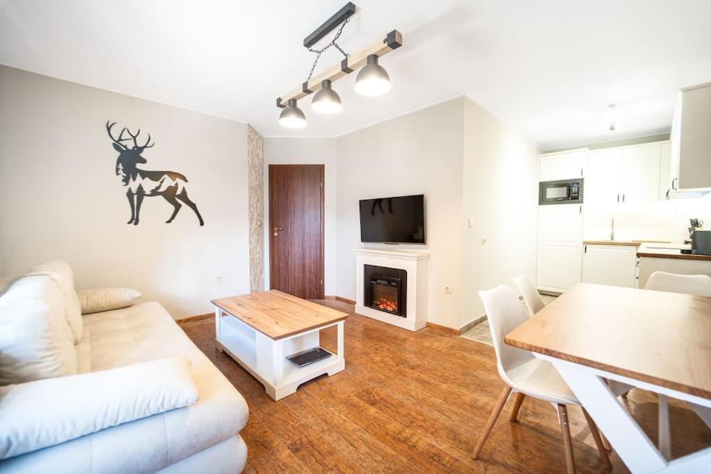 a living room with a couch and a table in it at 2BD App in Bojurland FREE Pool SPA Parking and Skishuttle in Bansko