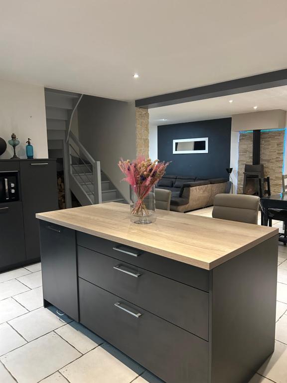 - une cuisine avec un comptoir orné d'un vase de fleurs dans l'établissement Maison spacieuse, à Marennes