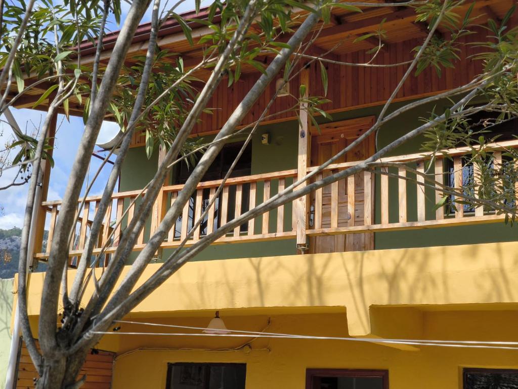 a balcony of a house with a wooden deck at Fire Pansiyon in Cıralı
