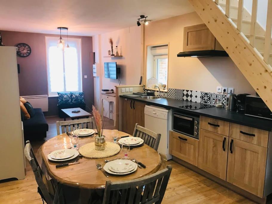 a kitchen with a wooden table with chairs and a dining room at Le franc 1949 in Toussaint