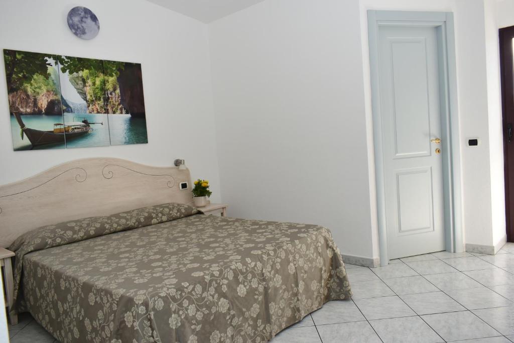 1 dormitorio con 1 cama y una foto en la pared en Hotel Quasar en Cala Liberotto