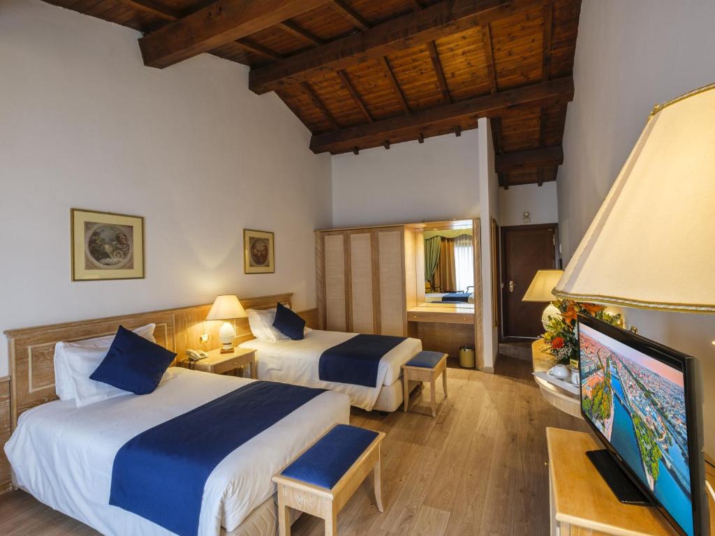 Postel nebo postele na pokoji v ubytování Hotel Orologio