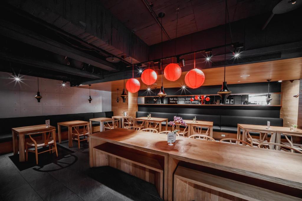 a restaurant with wooden tables and chairs and lights at Hub Hotel Kaohsiung Yawan Branch in Kaohsiung