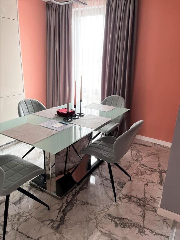 een eetkamer met een glazen tafel en stoelen bij Apartmenthaus Oborishte 5 in Panagyurishte