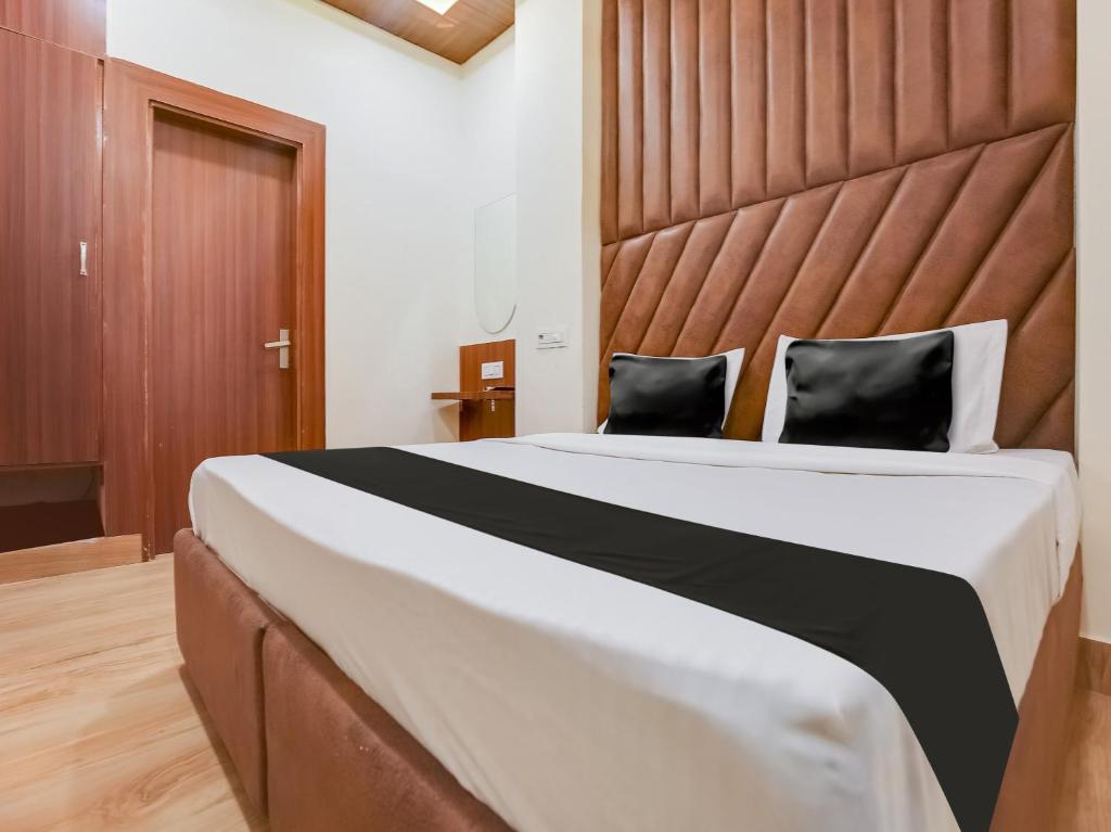 um quarto com uma cama grande e uma grande cabeceira. em OYO Hotel Blessing em Karnal