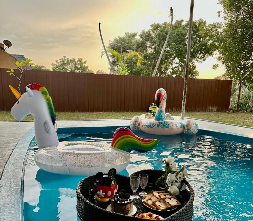 a pool with a toy unicorn and a ride in a swimming pool at A Famosa resort villa 877 snooker karaoke BBQ 5BR in Kampong Alor Gajah