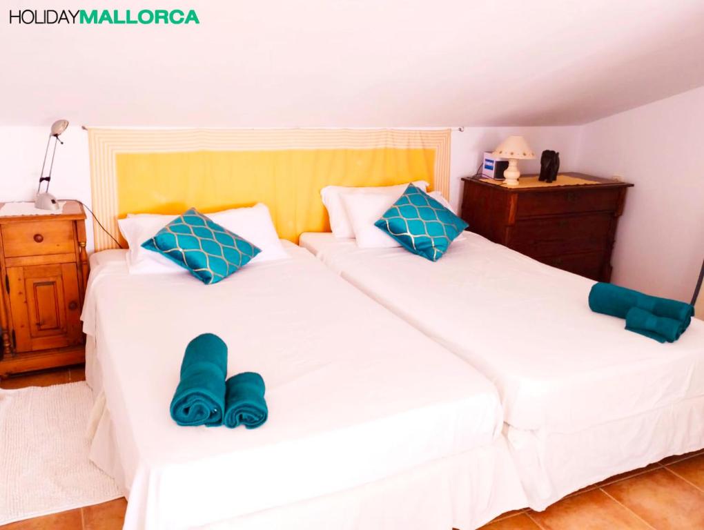 Dos camas en una habitación con zapatillas azules. en Aucanada Love Nest, en Alcudia