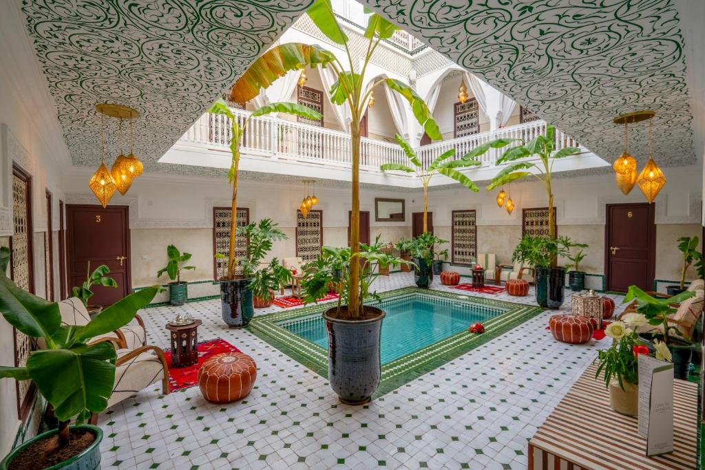 een hotel met een zwembad en planten in een kamer bij Riad Nuits D'orient Boutique Hotel & SPA in Marrakesh