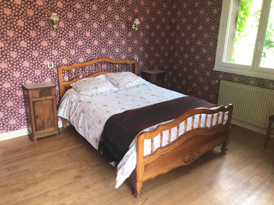 1 dormitorio con cama de madera y suelo de madera en Paris’s, en Balaguères