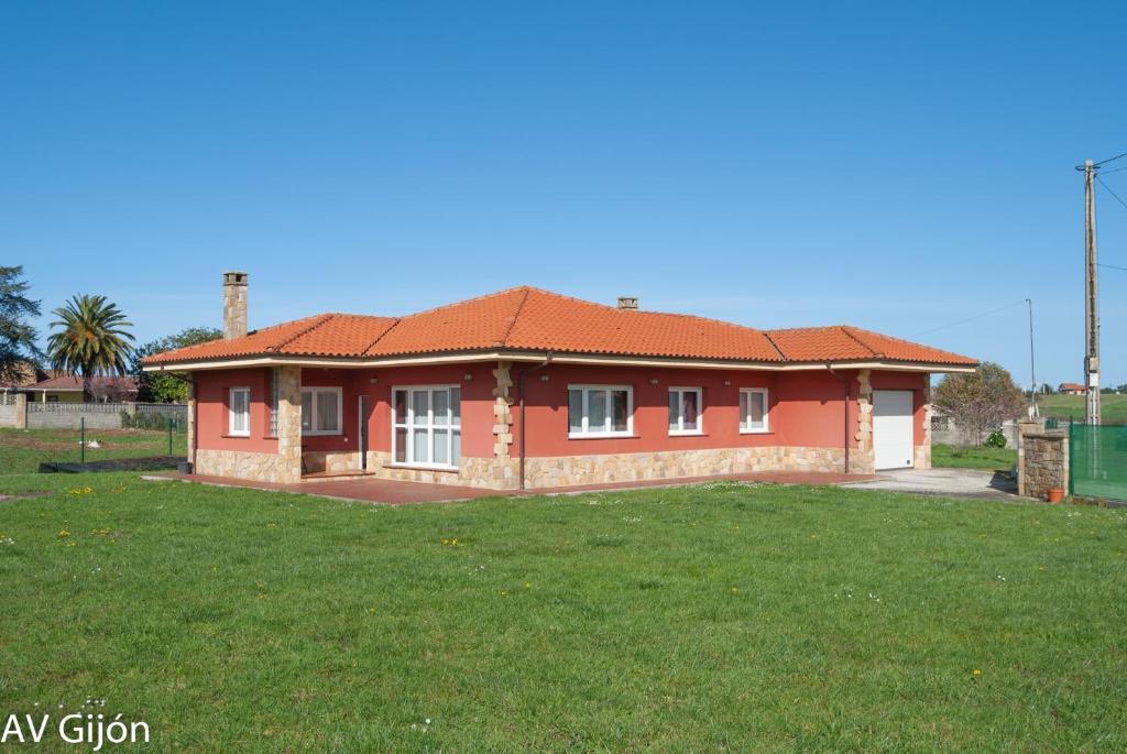 a small red house with a green yard at AV Casa Aurora - Quintes in Villaviciosa