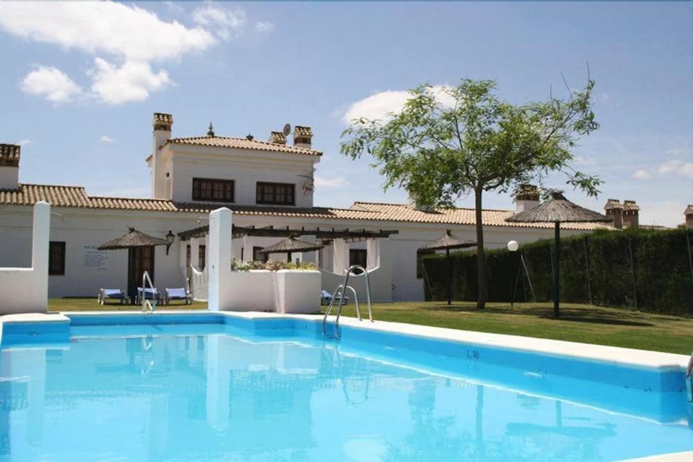 a large blue swimming pool in front of a house at Hotel Tugasa Villa de Algar in Algar