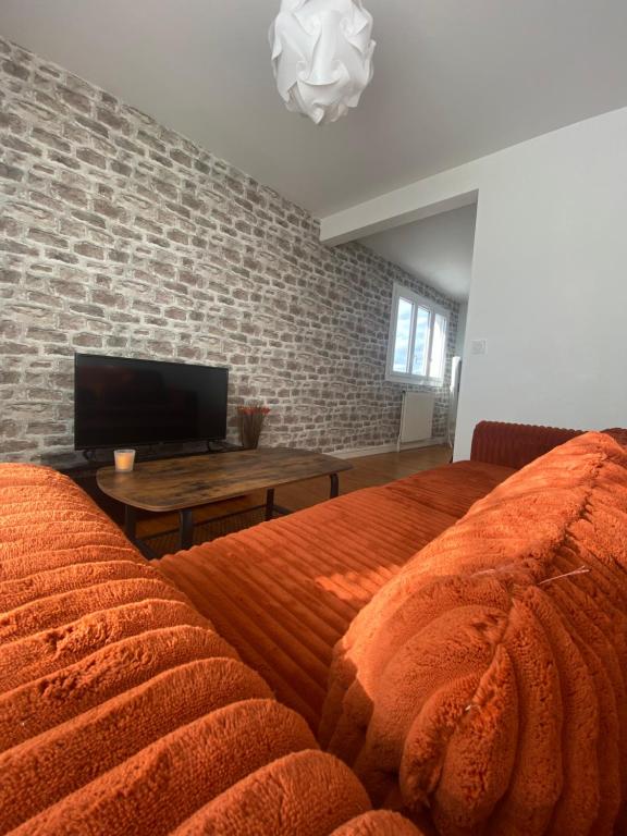 a bedroom with a large bed and a television at Appartement spacieux avec parking in Lempdes