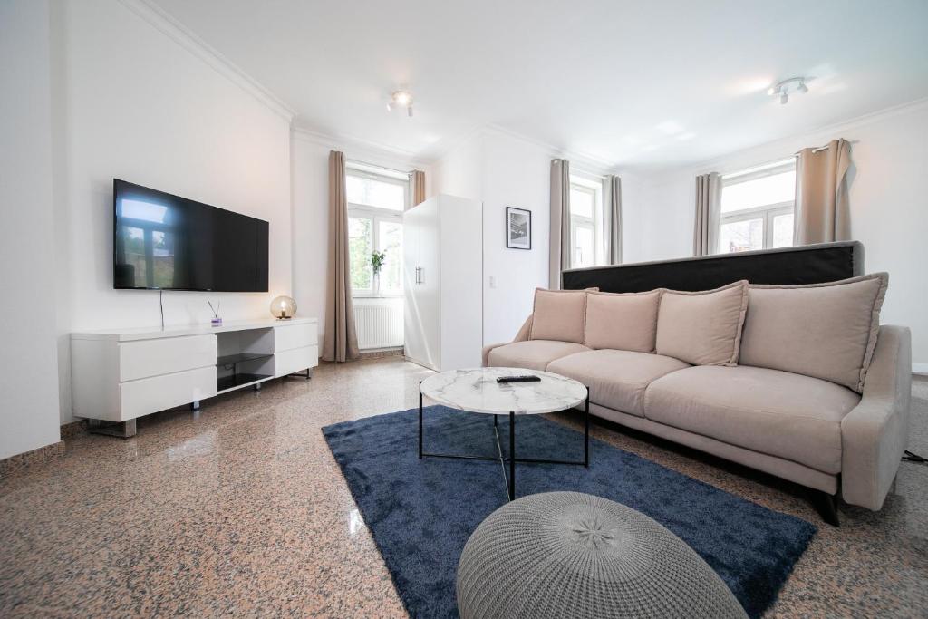ein Wohnzimmer mit einem Sofa und einem TV in der Unterkunft Apartments - Kitchen & More in Düsseldorf