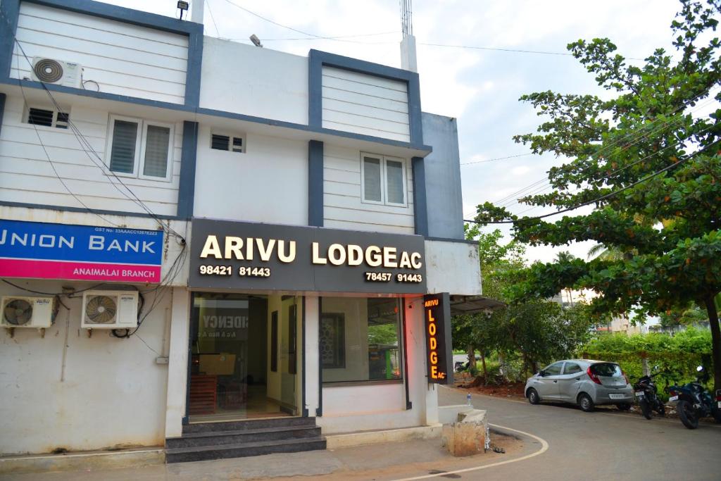 a building with an amu lodgers sign in front of it at ARIVU LODGE AC in Coimbatore