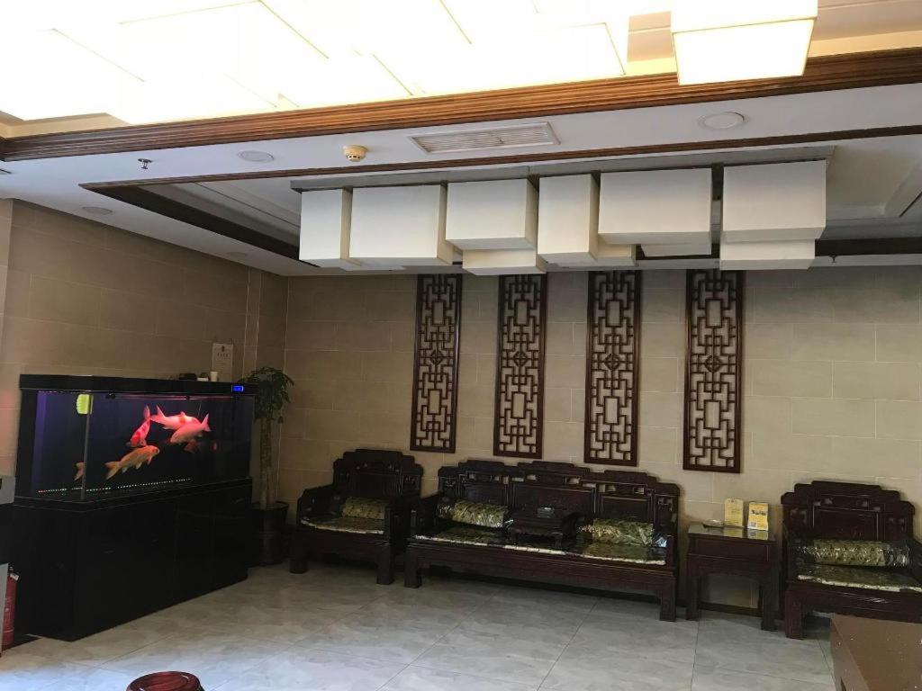 um quarto com uma televisão de ecrã plano e 3 camas em PAI Hotels Jinzhou Yi County Railway Station em Yi