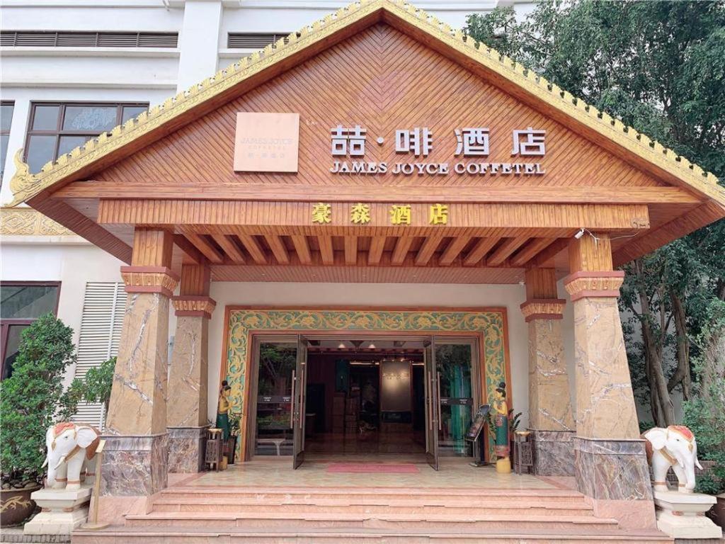 uma entrada para um edifício com uma placa em James Joyce Coffetel Xishuangbanna Gaozhuang Starlight Night Market em Jinghong