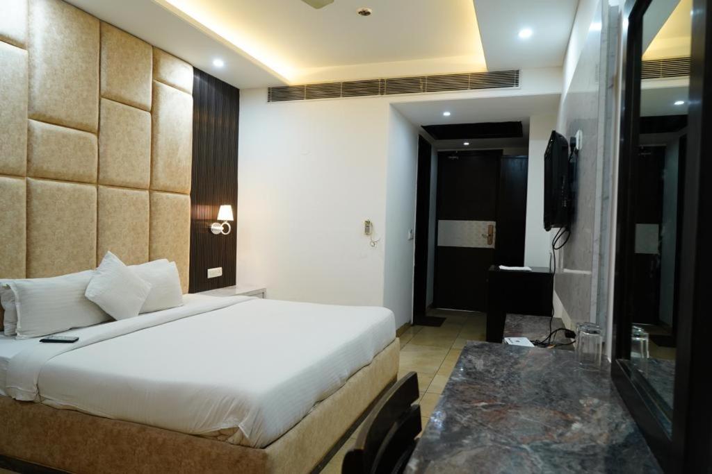 une chambre d'hôtel avec un lit et une télévision dans l'établissement Hotel Raunak, à Pinjaur