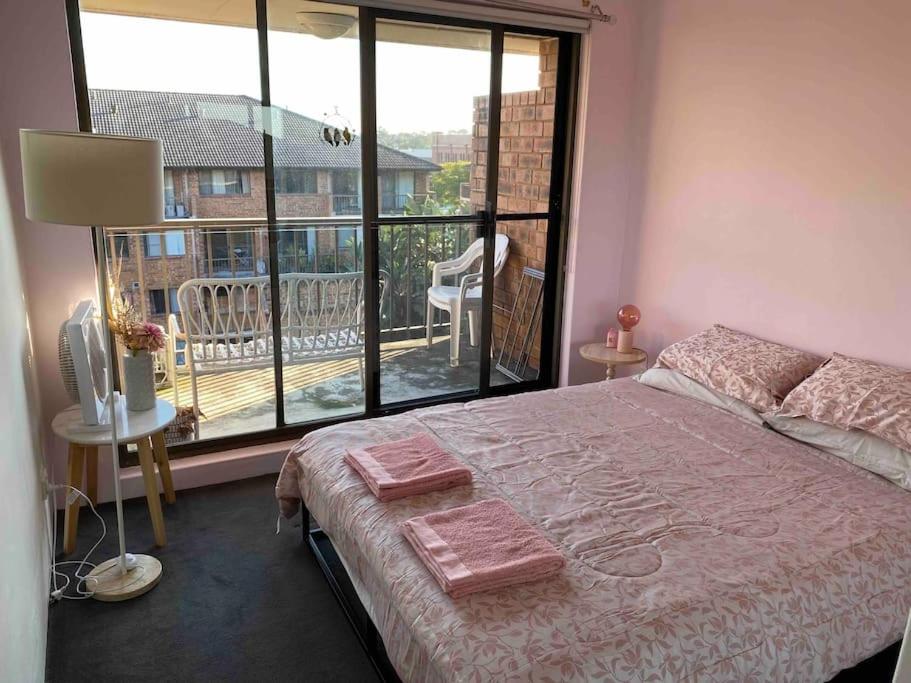 a bedroom with a bed and a large window at Sydney city meets village living in Sydney