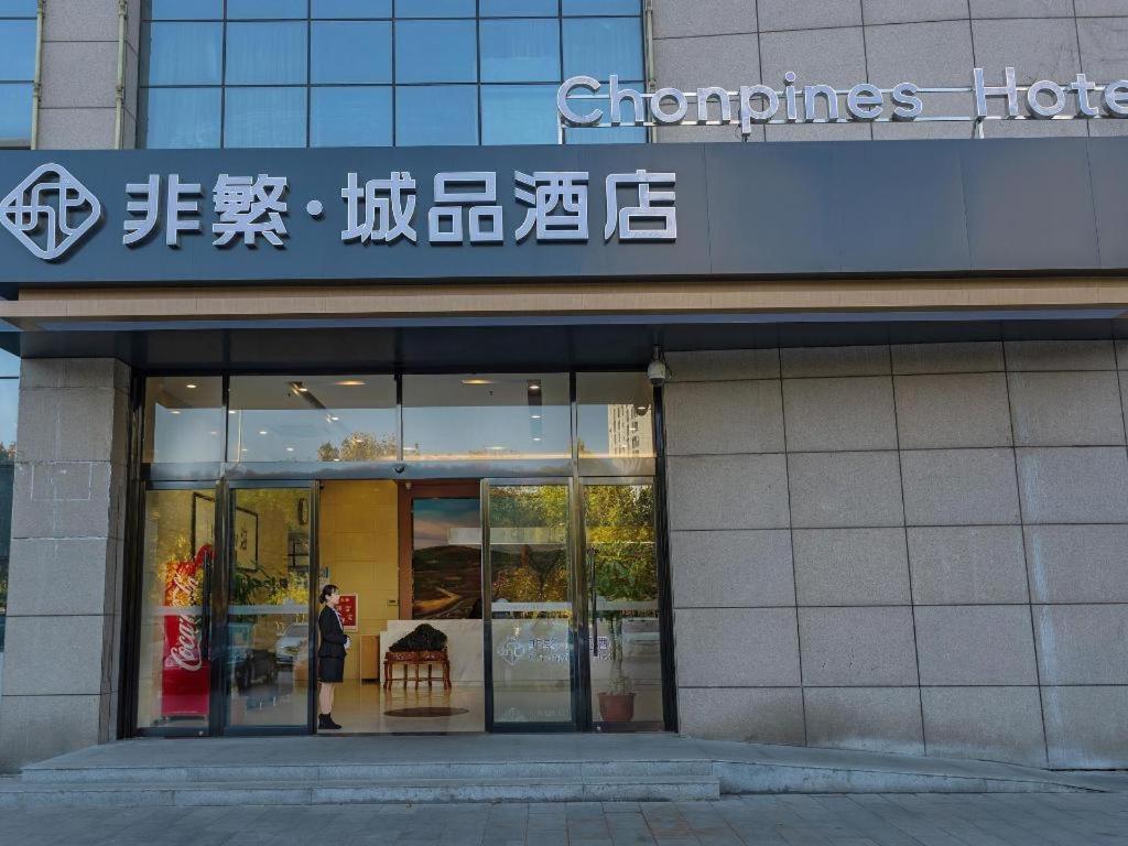 a woman standing outside of a store with a sign at Chonpines Hotel Jining Quanmin Fitness Plaza in Jining