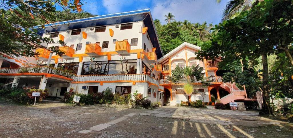 Mt. Bagarabon Beach Hotel في Mabua: مبنى ابيض كبير عليه بلكونات