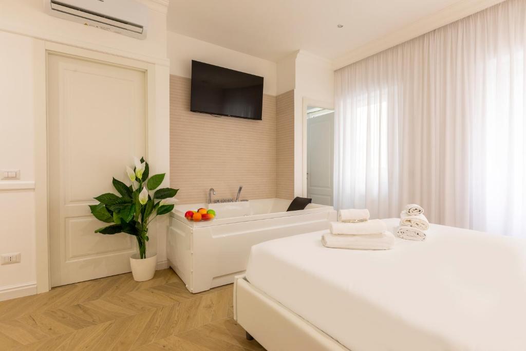 FARNESINA SUITE في روما: حمام أبيض مع حوض استحمام وتلفزيون على الحائط