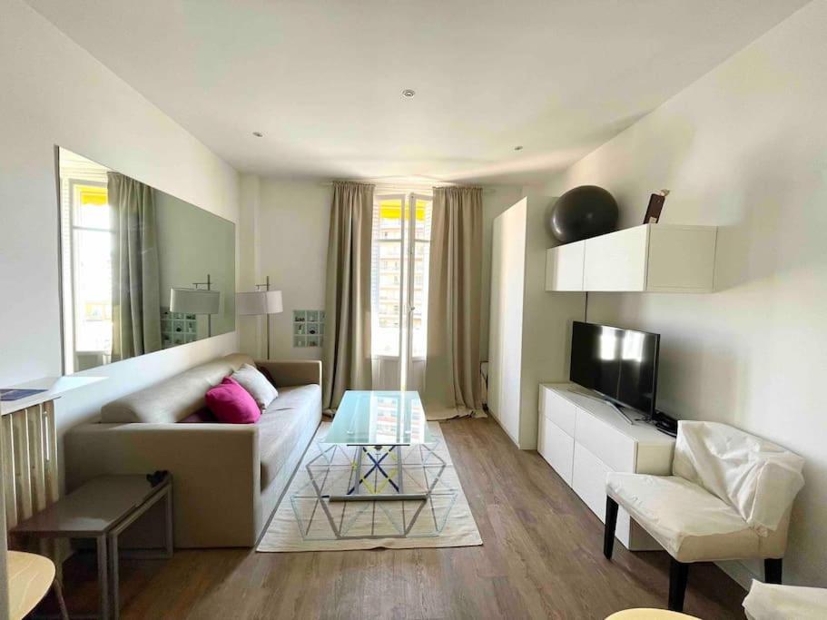 ein Wohnzimmer mit einem Sofa und einem Tisch in der Unterkunft Cute comfortable apartment with Monaco & sea view in Beausoleil