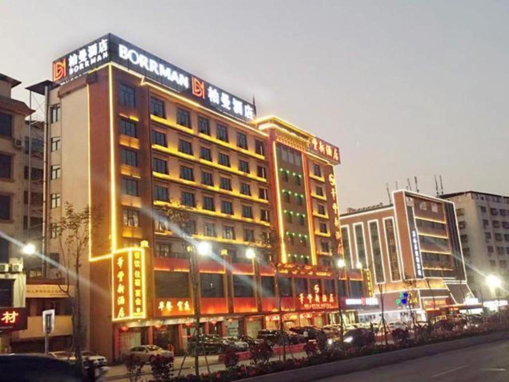 a large building with lights on in a city at night at Borrman Hotel Meizhou Mei County Airport in Meizhou
