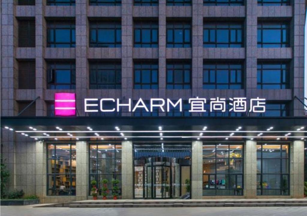 a building with a sign on the front of it at Echarm Hotel Wuhan Tianhe Airport Outlets in Huanghualao