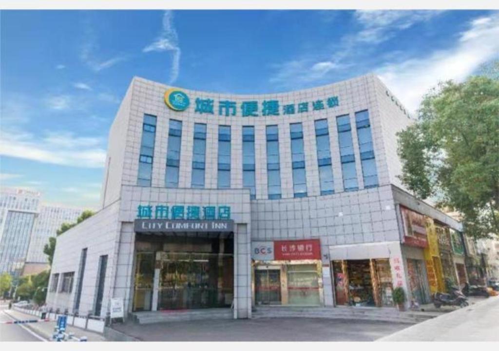 duży biały budynek z znakiem na górze w obiekcie City Comfort Inn Hunan Biological Electromechanical College East Station w mieście Xingsha